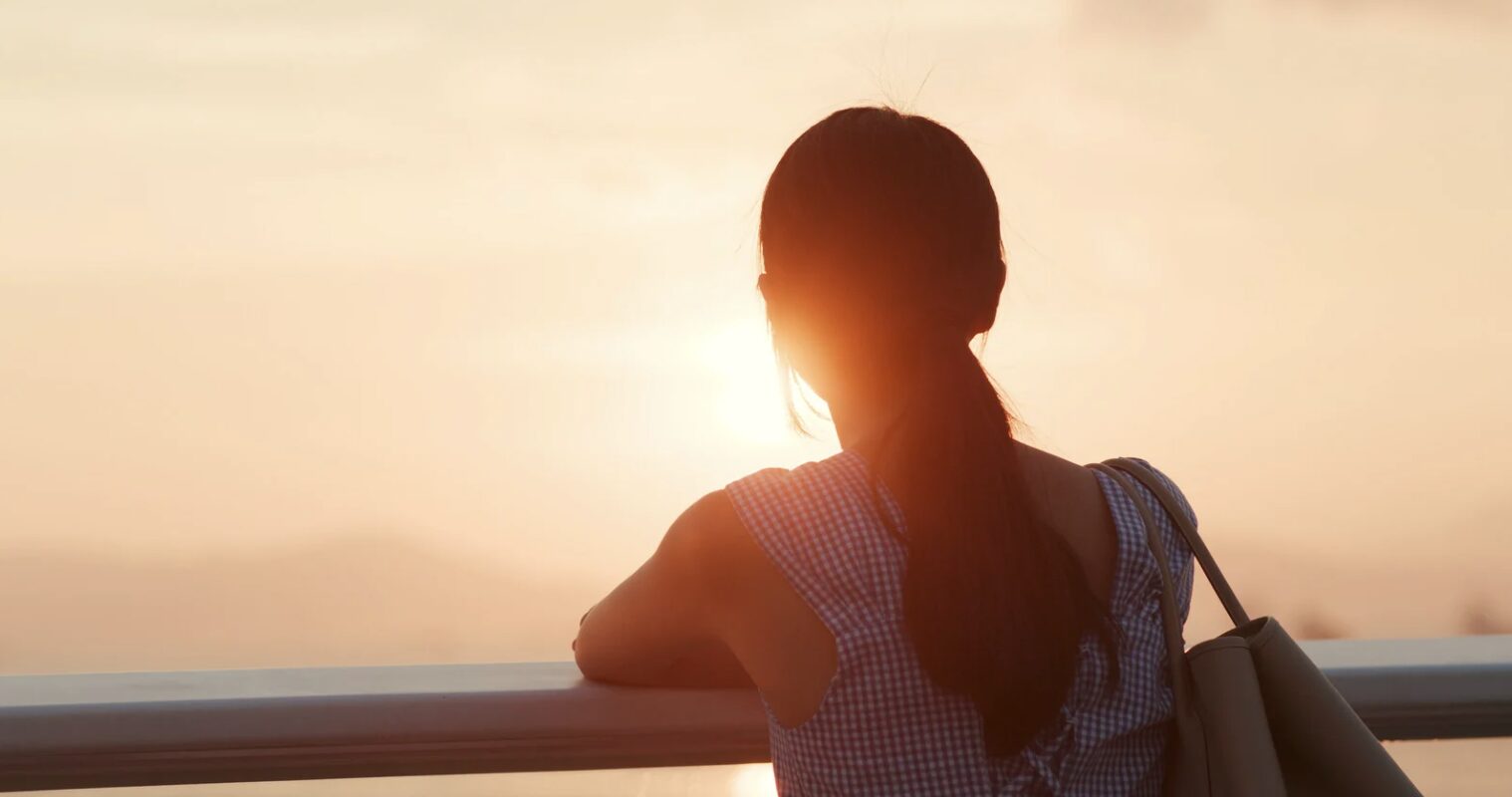 窓辺で静かに佇む女性
