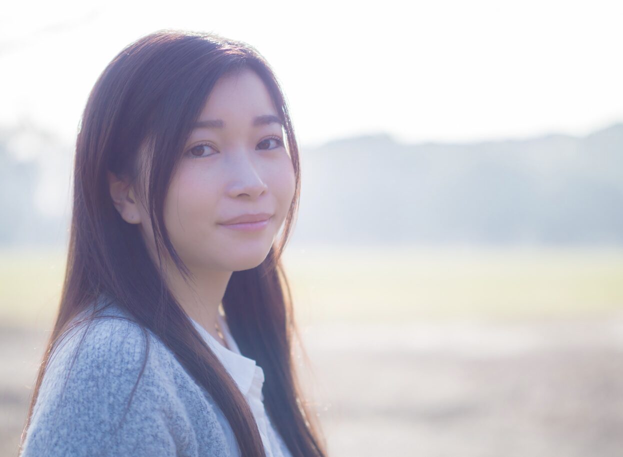 風に向かって両手を広げる女性